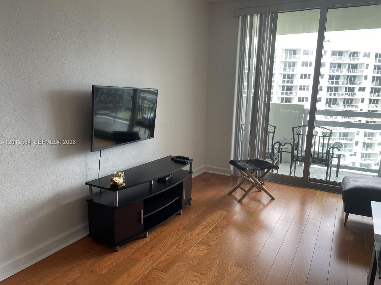 1500 Bay Road, Unit 1142S Miami Beach, FL 33139 - Photo 4 of 8 a living room with furniture flat screen tv and a large window
