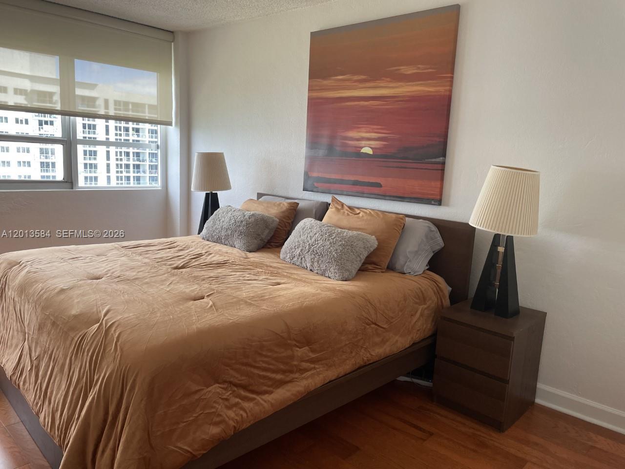 1500 Bay Road, Unit 1142S Miami Beach, FL 33139 - Photo 5 of 8 a large bed sitting in a bedroom next to a window