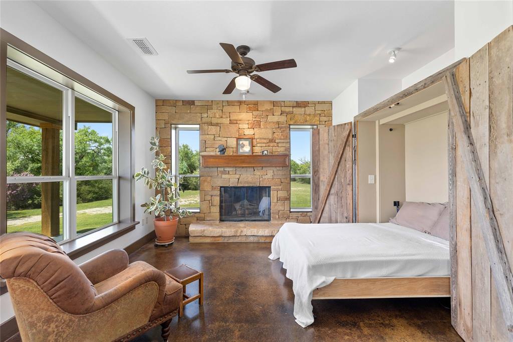 11253 County Road 525 May, TX 76857 - Photo 26 of 40 a spacious bedroom with a balcony a bed couch and a large window
