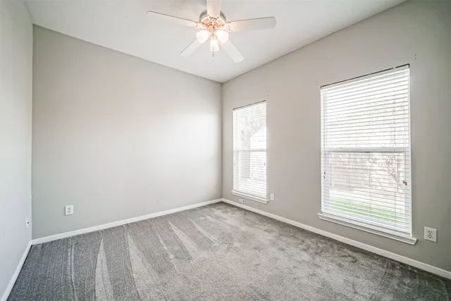 an empty room with closet and windows