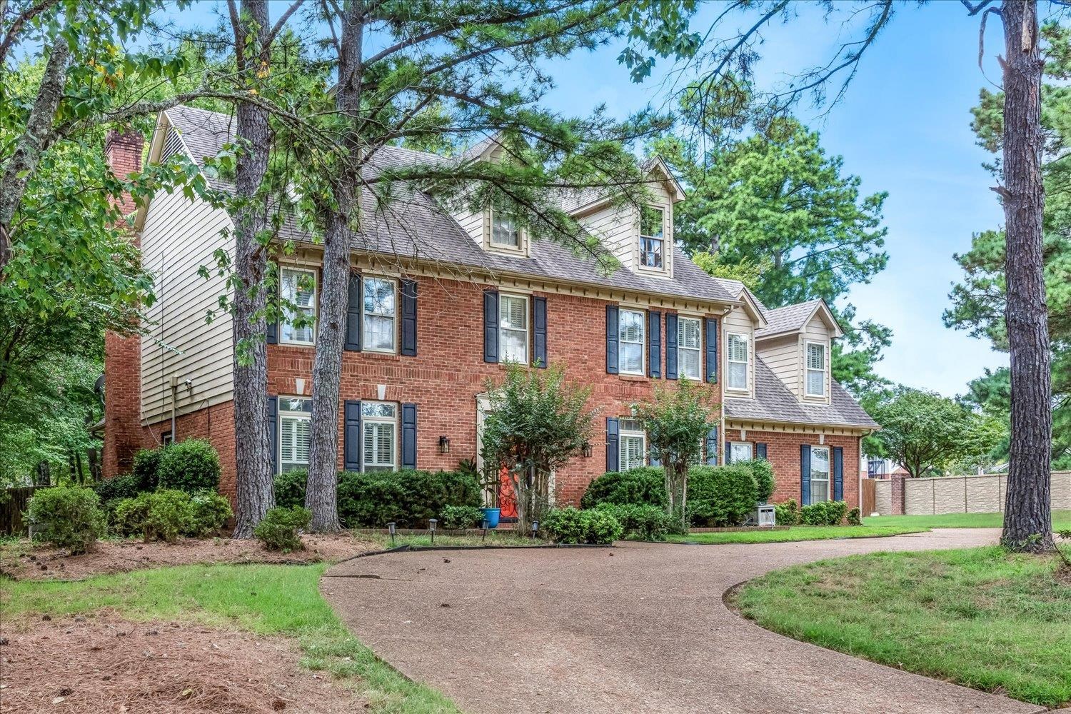 65 Summer Grove Road Memphis, TN 38018 - Photo 3 of 38 Brick and siding exterior with multiple dormer windows, featuring a paved driveway and mature trees