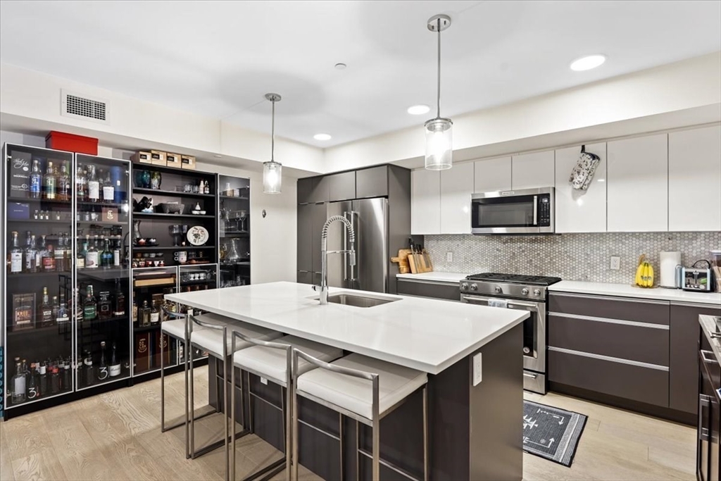 a kitchen that has a table chairs stainless steel appliances and cabinets