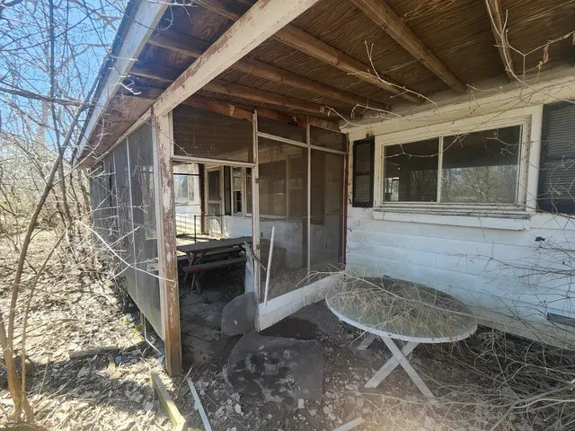 a view of house with backyard and outdoor seating