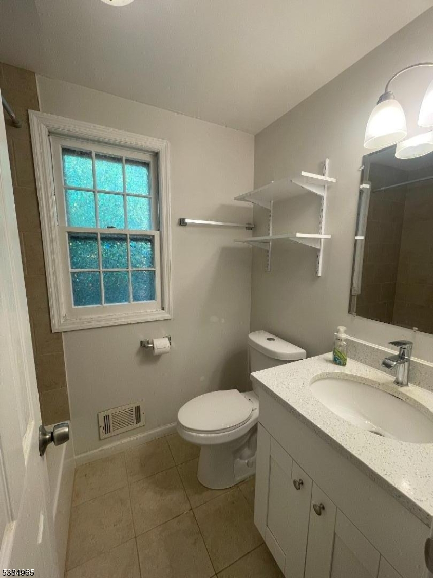 114 Osprey Road, Unit 114 Hackettstown, NJ 07840 - Photo 5 of 8 a bathroom with a granite countertop sink toilet and a mirror