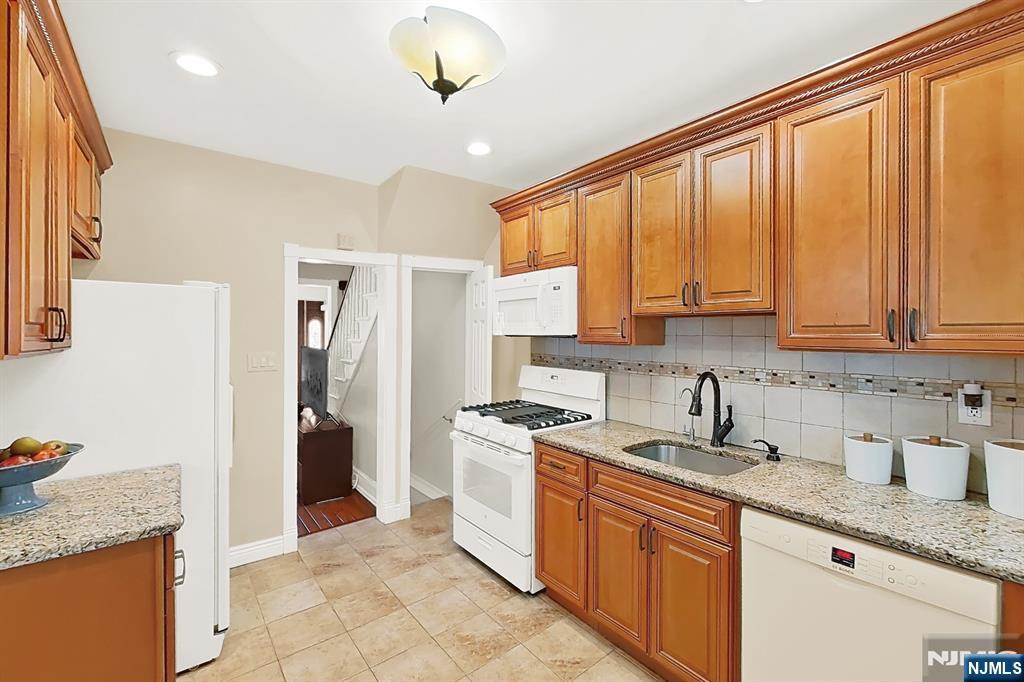 438 Forest Street Kearny, NJ 07032 - Photo 24 of 38 a kitchen with stainless steel appliances granite countertop a sink a stove and a refrigerator