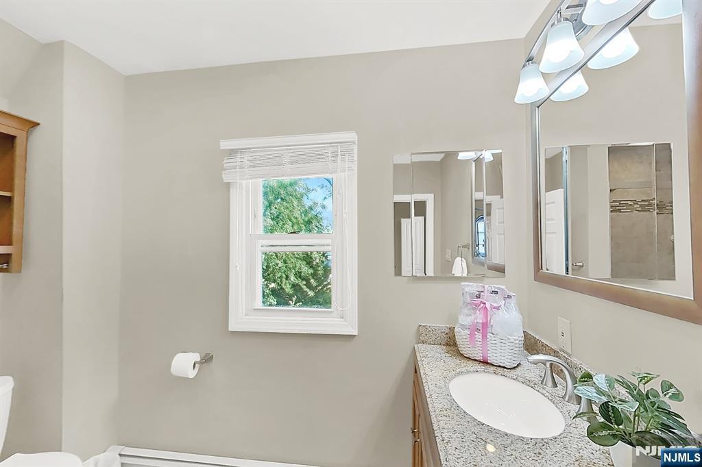 438 Forest Street Kearny, NJ 07032 - Photo 31 of 38 a bathroom with a granite countertop sink and a mirror