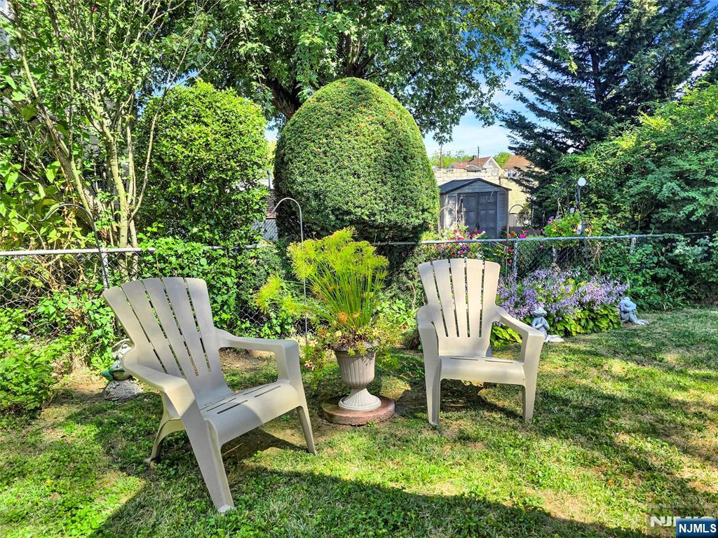 438 Forest Street Kearny, NJ 07032 - Photo 7 of 38 a wooden bench sitting in the middle of a garden