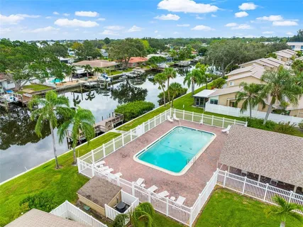a view of a swimming pool with a patio and a yard