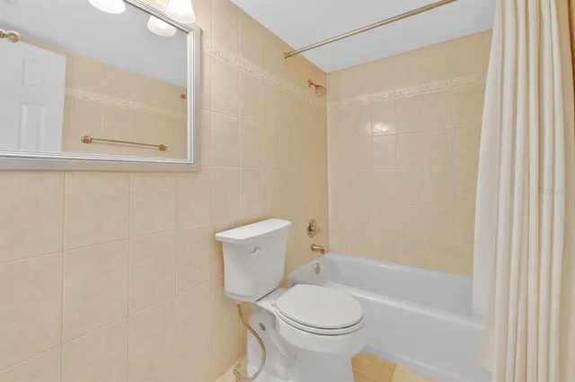 a white toilet sitting next to a bath tub