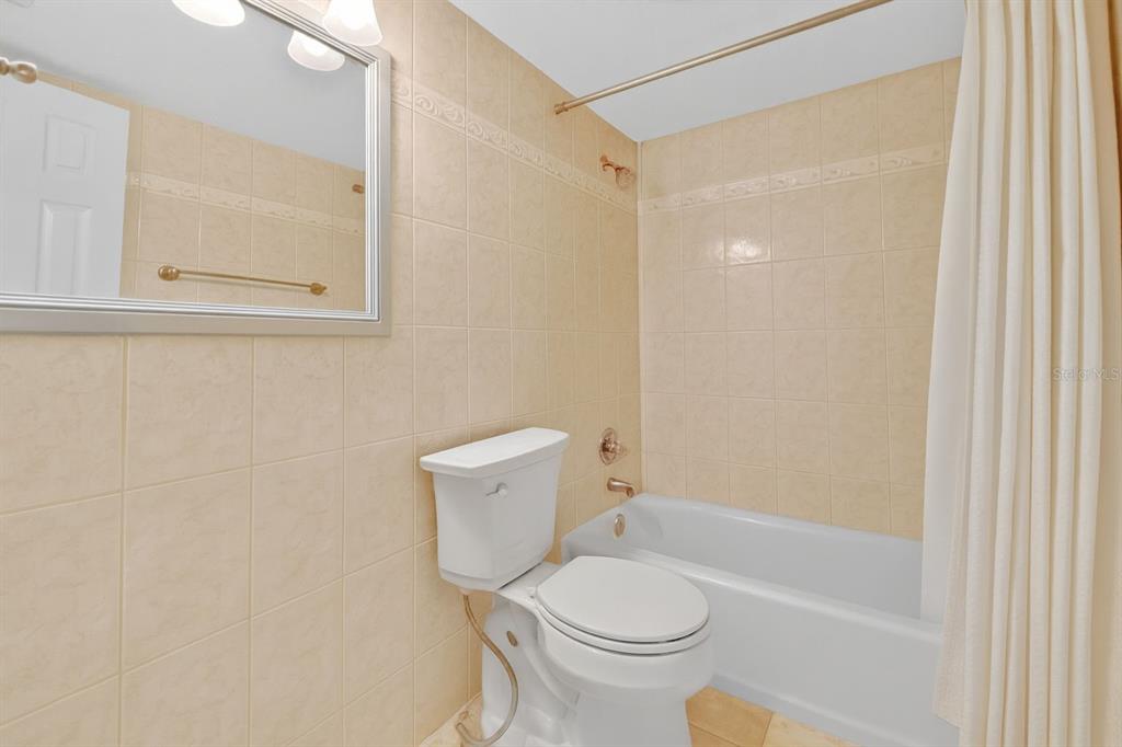 6525 Cape Sable Way Northeast, Unit 2 St. Petersburg, FL 33702 - Photo 9 of 26 a white toilet sitting next to a bath tub