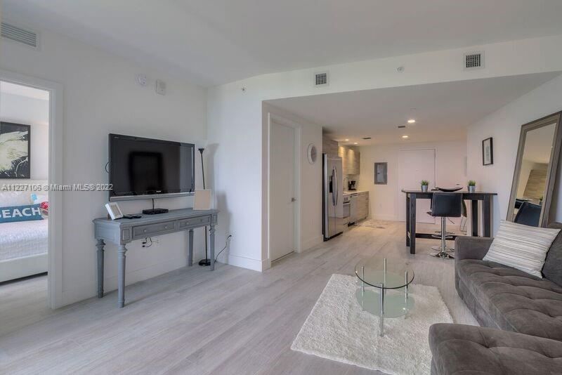 121 Northeast 34th Street, Unit 814 Miami, FL 33137 - Photo 11 of 38 a living room with furniture and a flat screen tv