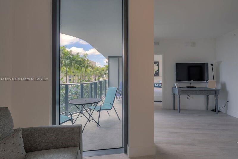121 Northeast 34th Street, Unit 814 Miami, FL 33137 - Photo 12 of 38 a view of a livingroom with furniture and a flat screen tv