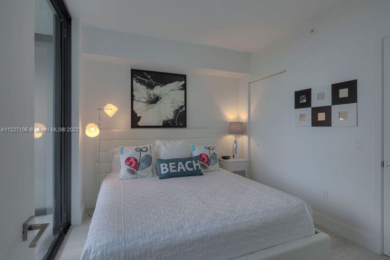 121 Northeast 34th Street, Unit 814 Miami, FL 33137 - Photo 13 of 38 a bedroom with a bed and painting on the wall