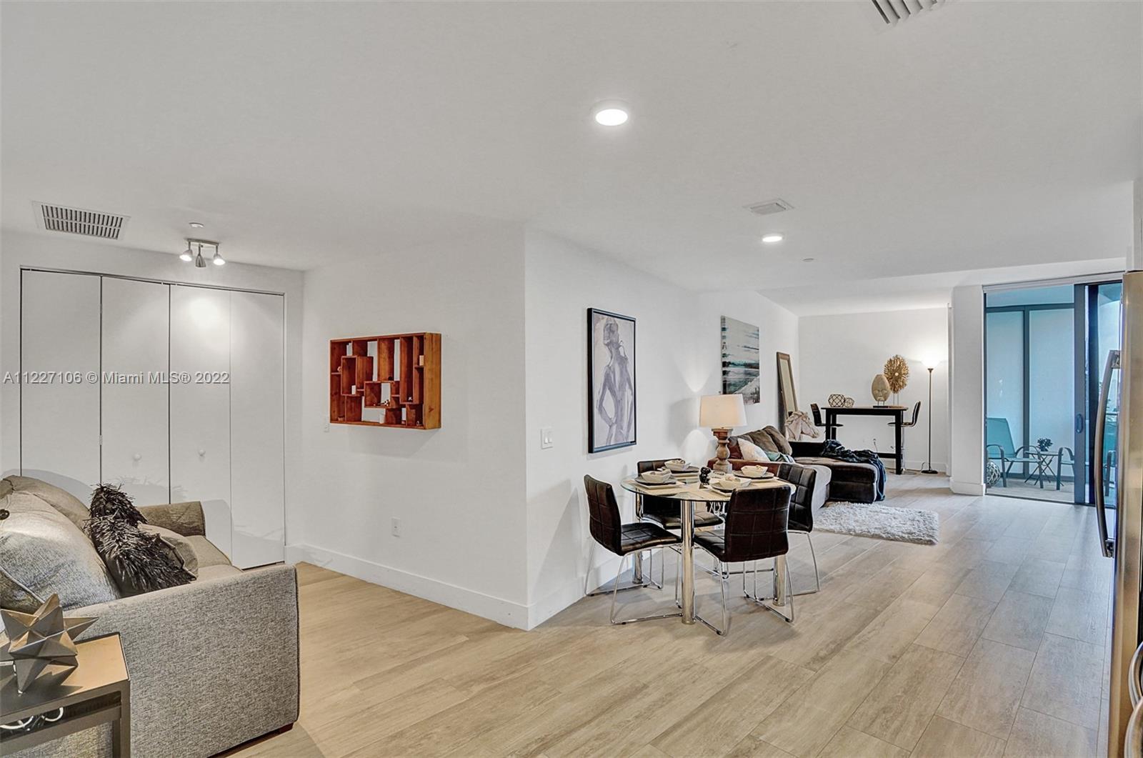 121 Northeast 34th Street, Unit 814 Miami, FL 33137 - Photo 23 of 38 a living room with furniture and wooden floor