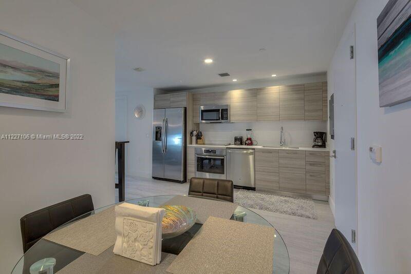 121 Northeast 34th Street, Unit 814 Miami, FL 33137 - Photo 3 of 38 a kitchen with a refrigerator and a sink