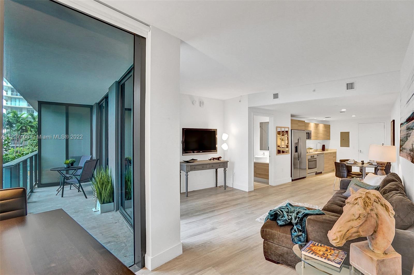 121 Northeast 34th Street, Unit 814 Miami, FL 33137 - Photo 33 of 38 a living room with furniture and a flat screen tv