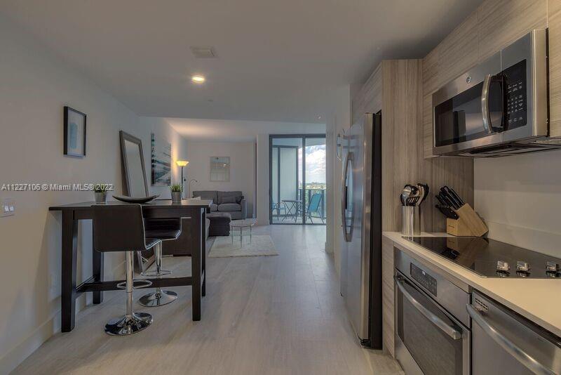 121 Northeast 34th Street, Unit 814 Miami, FL 33137 - Photo 5 of 38 a kitchen with stainless steel appliances granite countertop a refrigerator and microwave