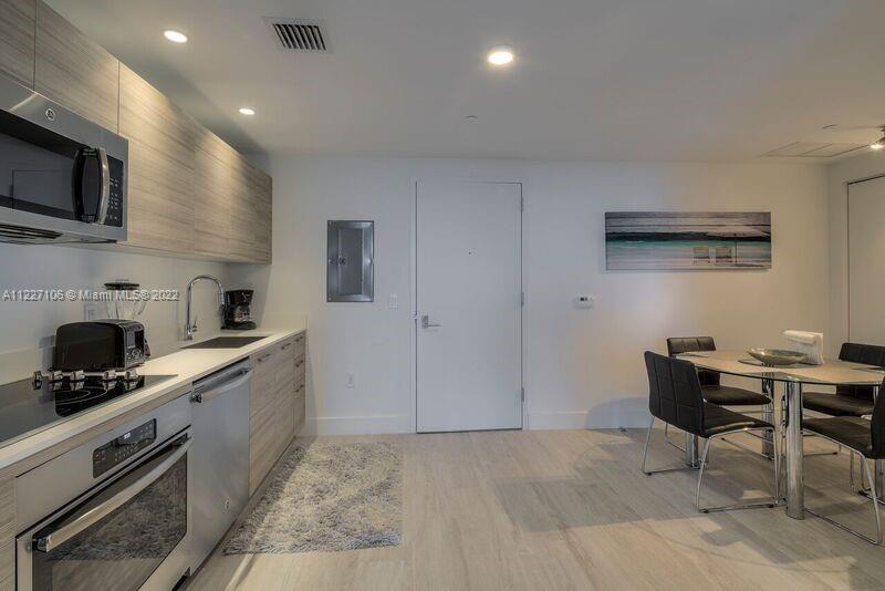 121 Northeast 34th Street, Unit 814 Miami, FL 33137 - Photo 6 of 38 a kitchen with granite countertop a sink and appliances
