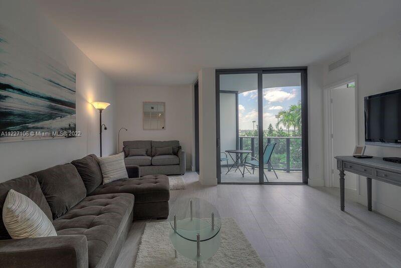 121 Northeast 34th Street, Unit 814 Miami, FL 33137 - Photo 7 of 38 a living room with furniture and a flat screen tv