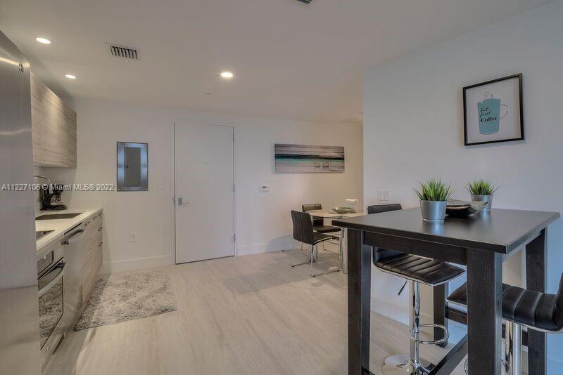 121 Northeast 34th Street, Unit 814 Miami, FL 33137 - Photo 8 of 38 a kitchen with a table and chairs in it