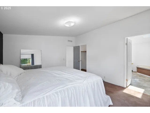 a bedroom with a bed and a painting on the wall