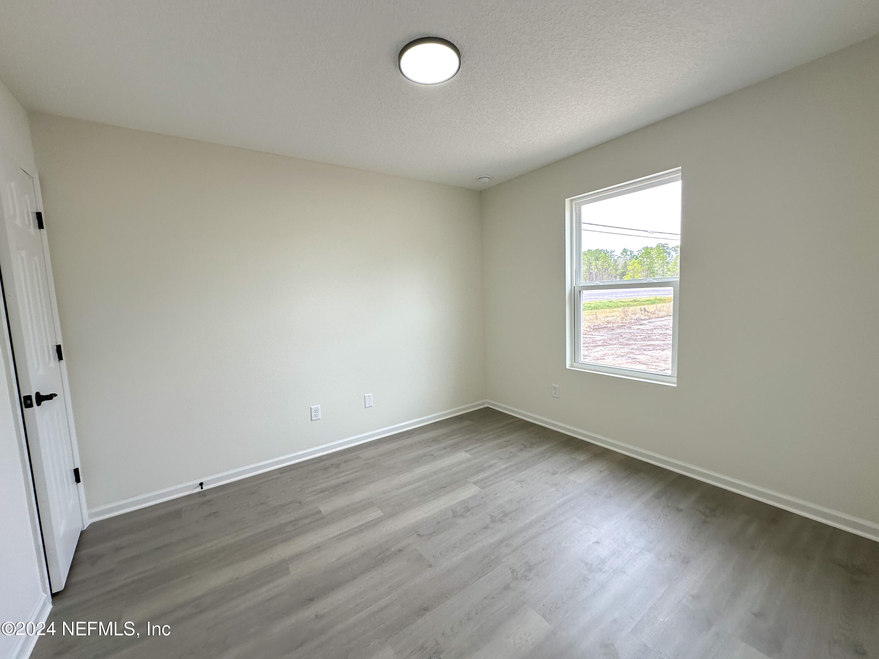1047 Fleming Street Fleming Island, FL 32003 - Photo 15 of 15 an empty room with wooden floor and windows