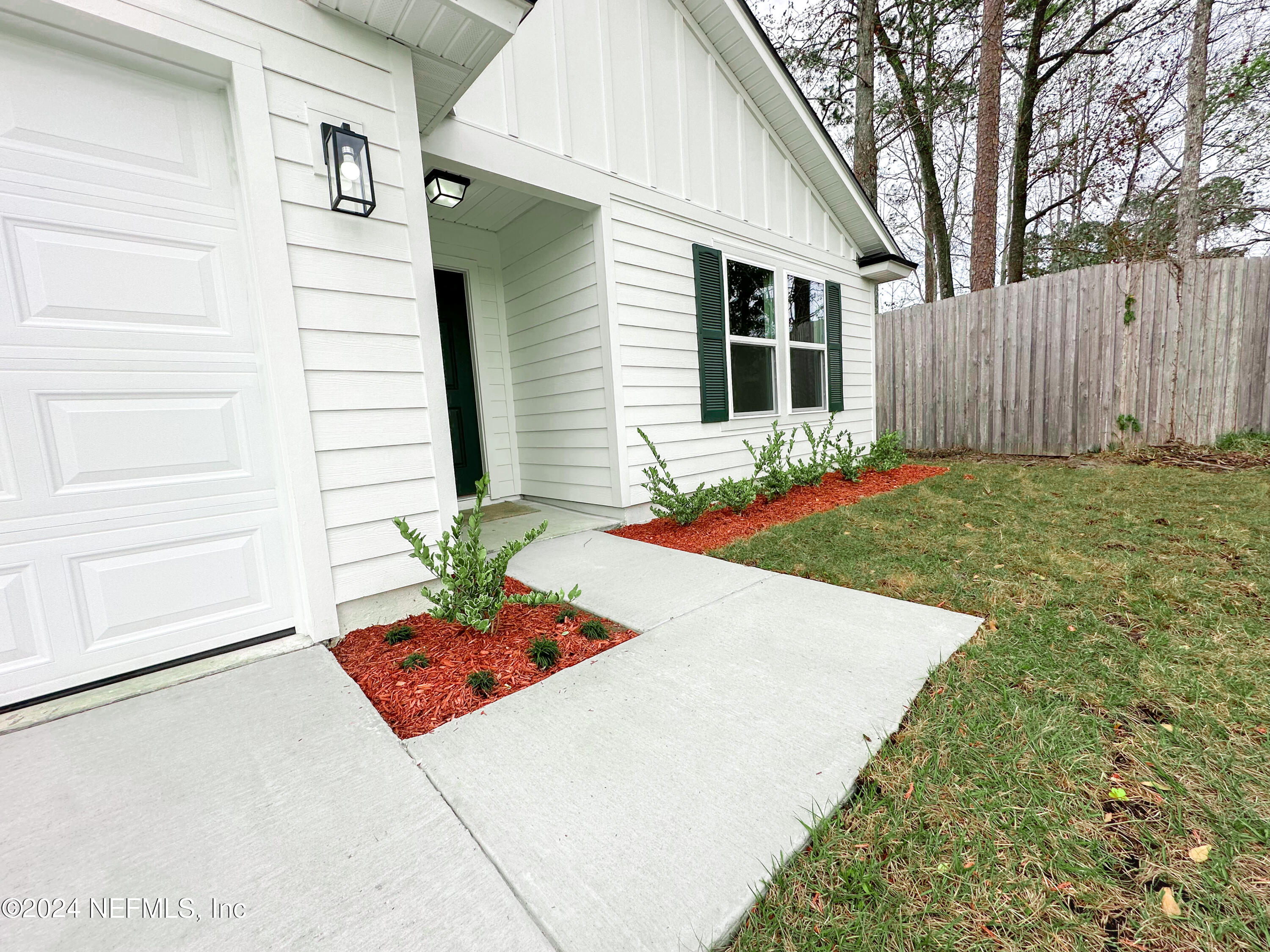 1047 Fleming Street Fleming Island, FL 32003 - Photo 2 of 15 a white house with a yard and potted plants