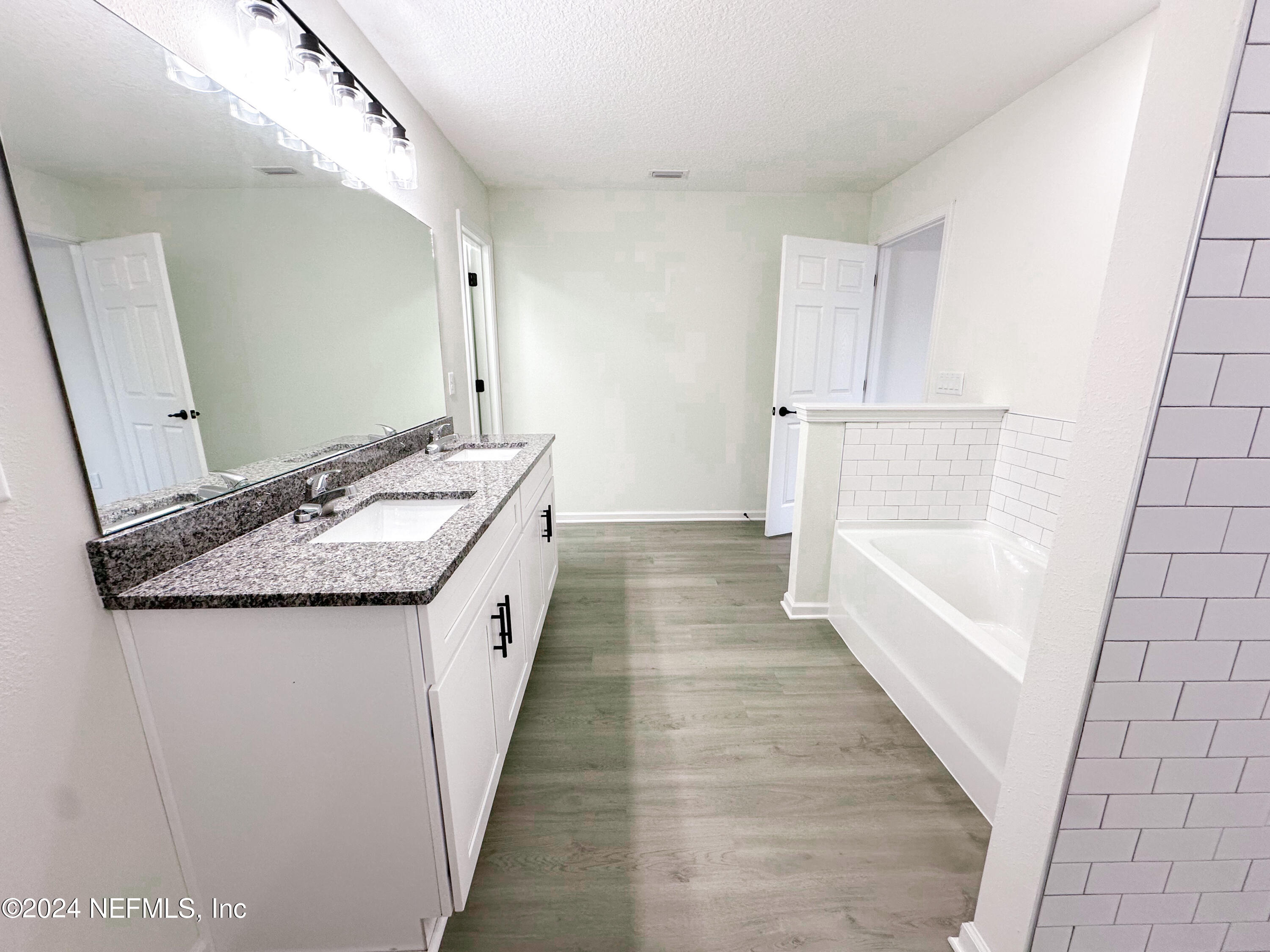 1047 Fleming Street Fleming Island, FL 32003 - Photo 10 of 15 a spacious bathroom with a granite countertop sink and a bathtub
