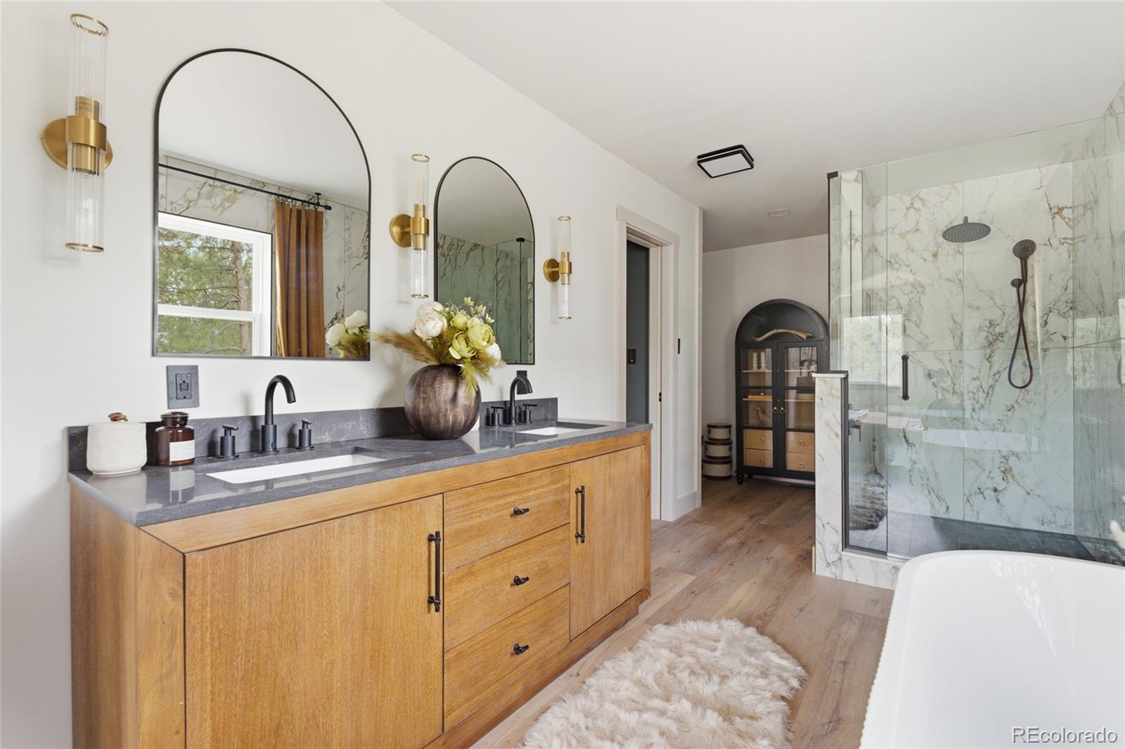 33691 Nova Road Pine, CO 80470 - Photo 26 of 41 a spacious bathroom with a double vanity sink a mirror and a shower