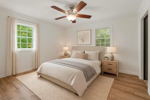 a bedroom with a bed a couch and dresser next to a window