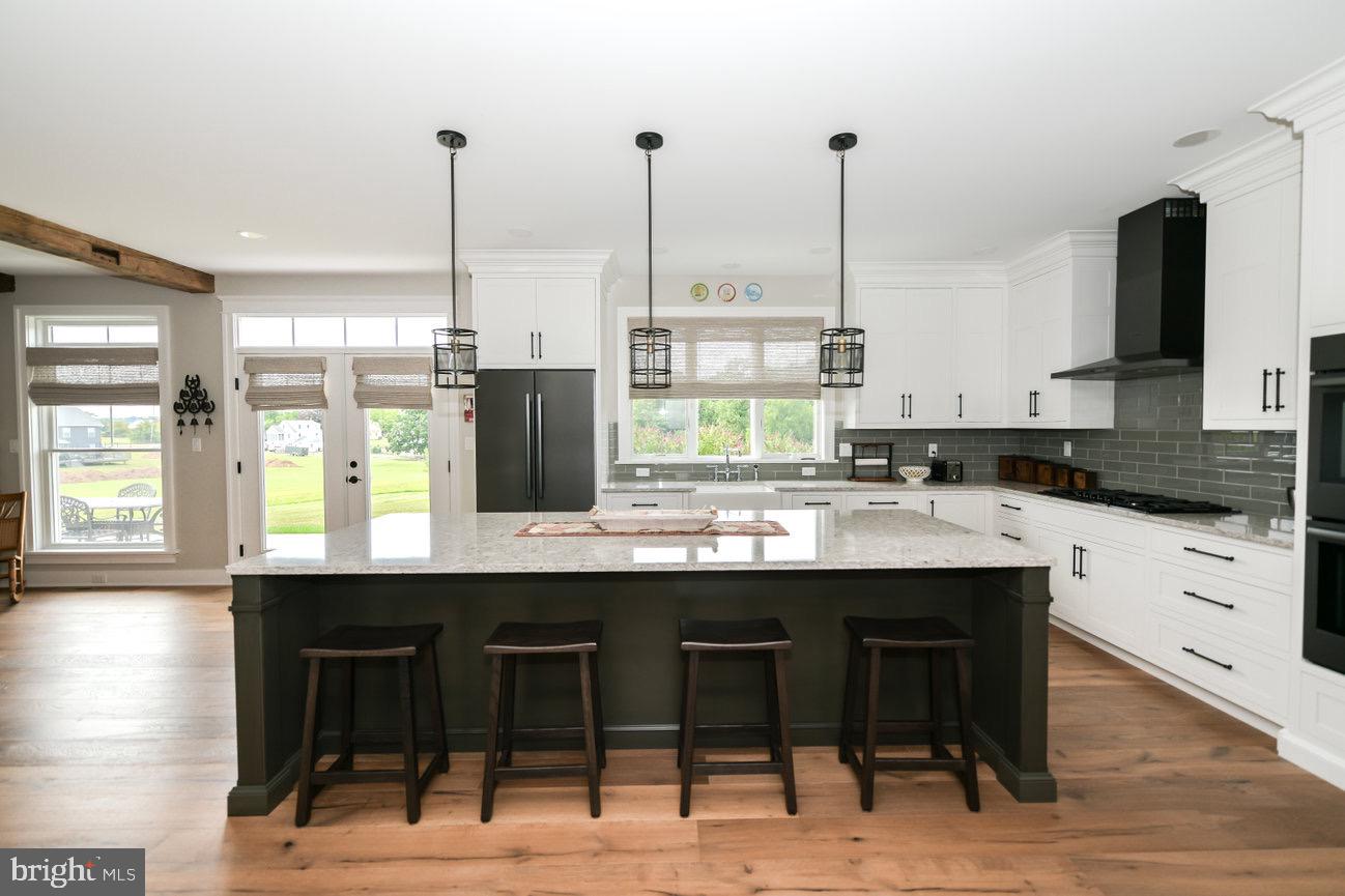 7091 Schoolhouse Road Hershey, PA 17033 - Photo 6 of 37 a kitchen with stainless steel appliances kitchen island a table chairs sink and cabinets