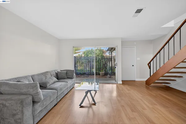 a living room with furniture and a wooden floor