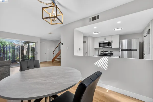 a living room with stainless steel appliances furniture a dining table and chairs