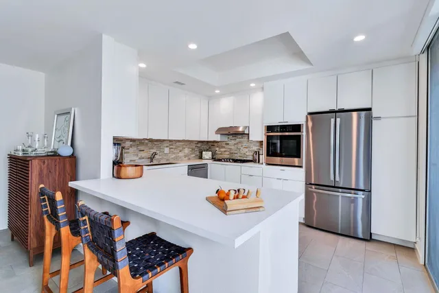 a kitchen with stainless steel appliances granite countertop a refrigerator and a stove