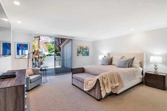 a spacious bedroom with a bed couch and a large window