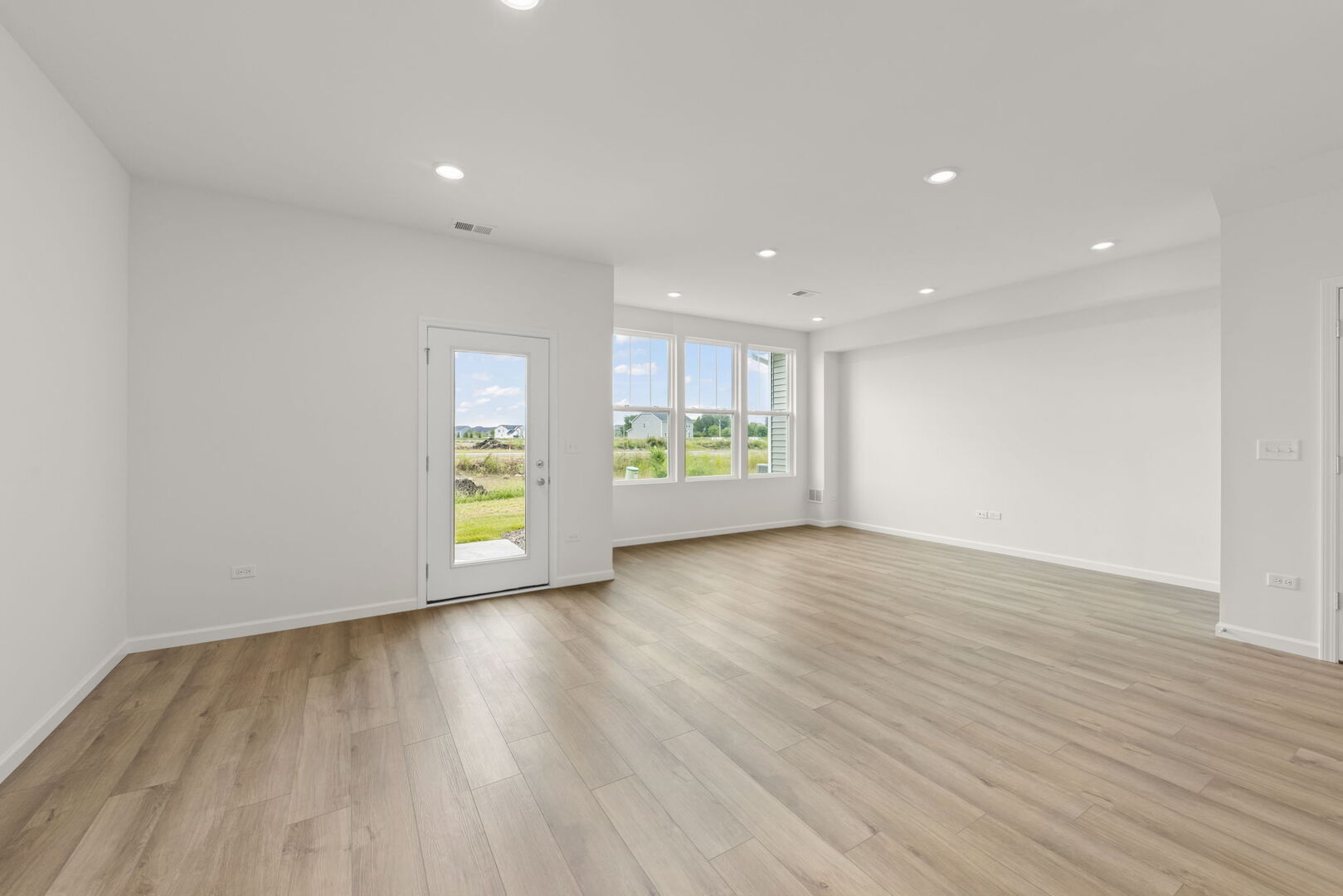 664 Switchgrass Way Bolingbrook, IL 60490 - Photo 11 of 35 a view of an empty room with window and wooden floor