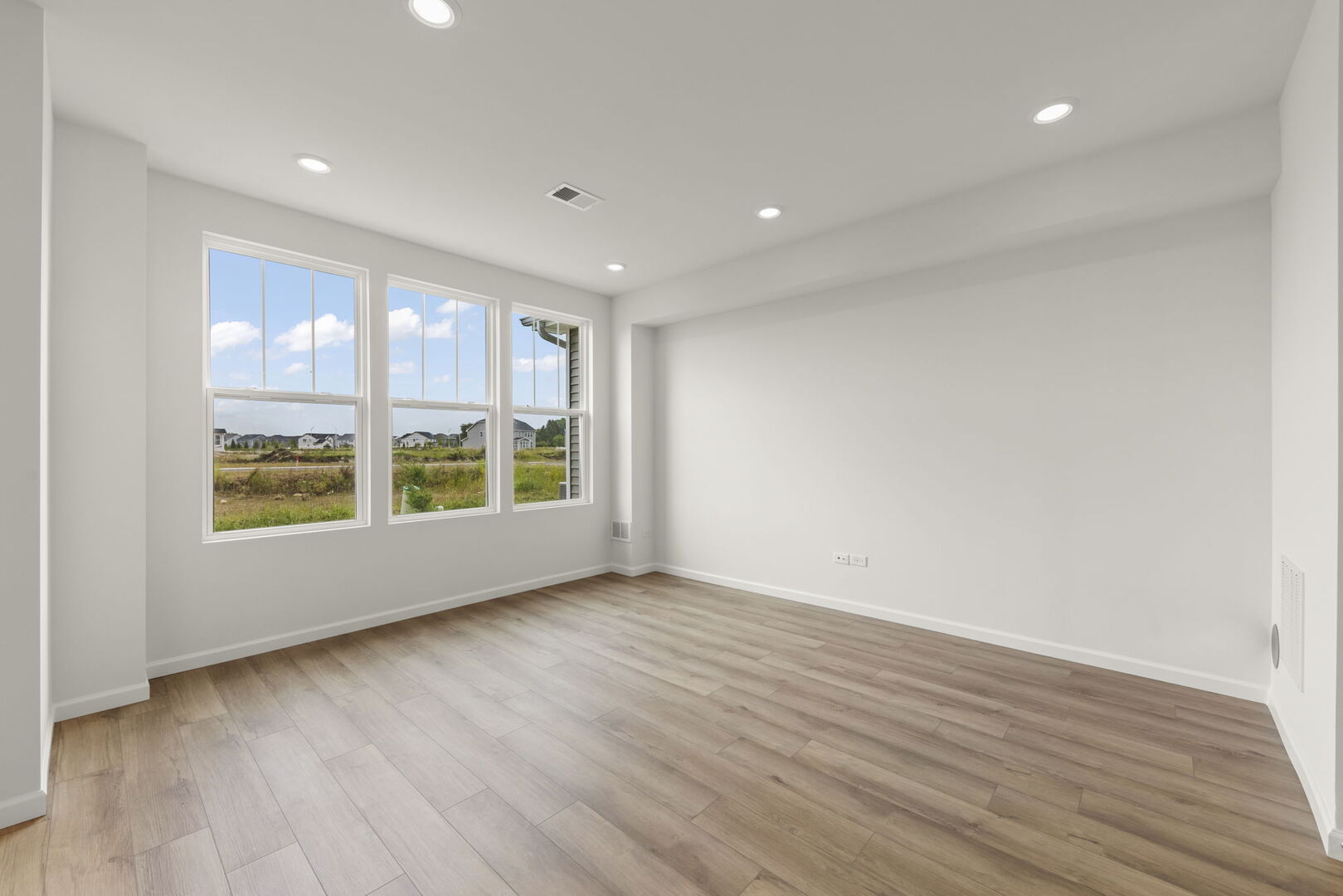 664 Switchgrass Way Bolingbrook, IL 60490 - Photo 12 of 35 a view of an empty room with a window and wooden floor