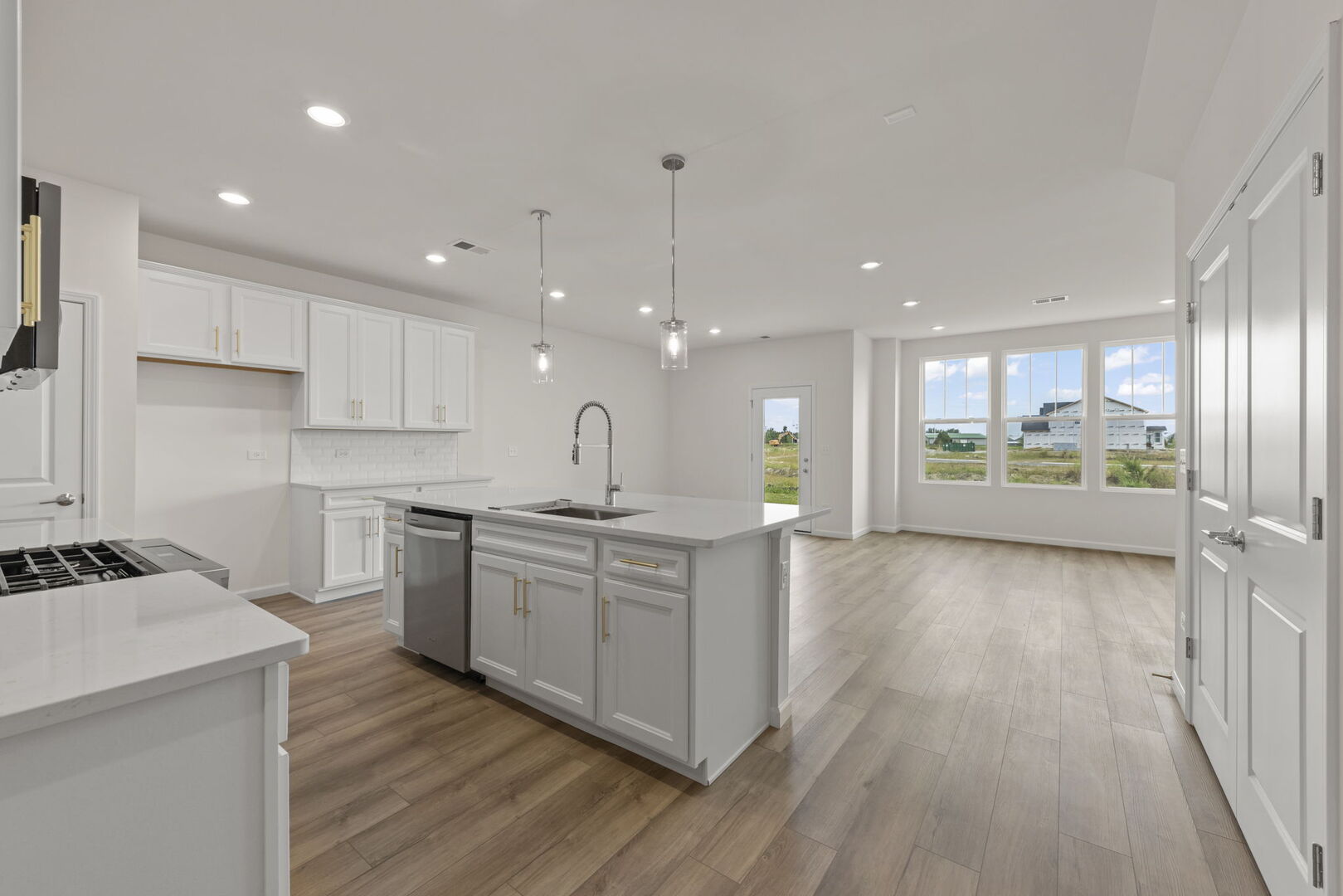 664 Switchgrass Way Bolingbrook, IL 60490 - Photo 4 of 35 a large kitchen with stainless steel appliances kitchen island a large counter top and a wooden floors
