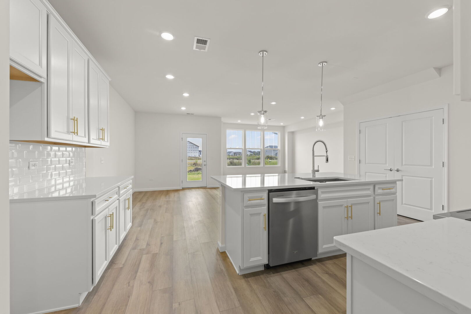 664 Switchgrass Way Bolingbrook, IL 60490 - Photo 6 of 35 a kitchen with stainless steel appliances kitchen island granite countertop a stove a sink and white cabinets with wooden floor
