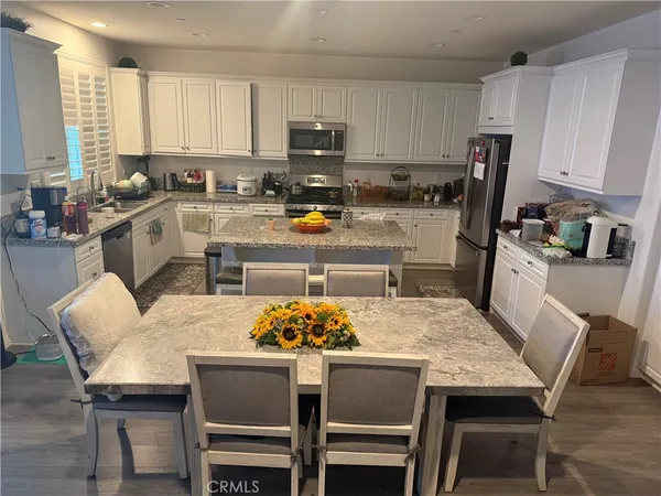 a kitchen with a dining table chairs and a stove top oven