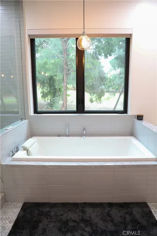 a bedroom with a bed and a flat tv screen next to a window