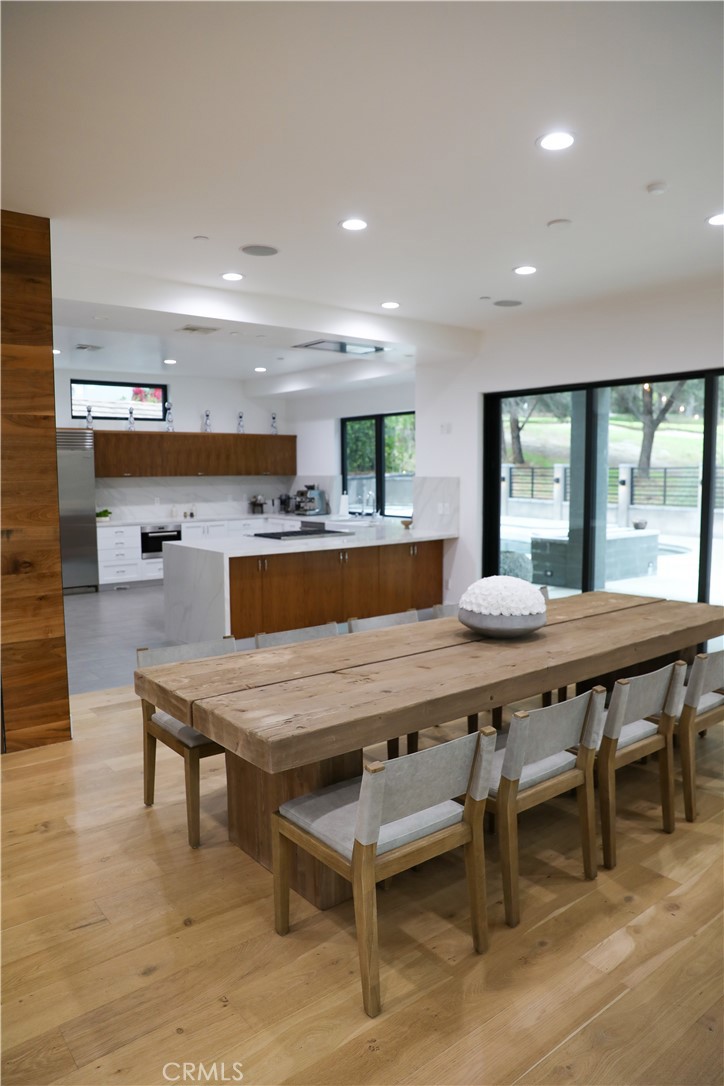 12664 McLennan Avenue Granada Hills, CA 91344 - Photo 4 of 61 a dining hall with stainless steel appliances granite countertop a table chairs and a refrigerator