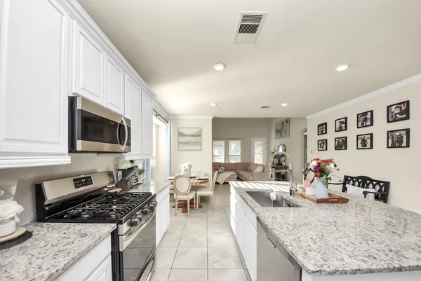 a open kitchen with stainless steel appliances granite countertop a sink and a refrigerator