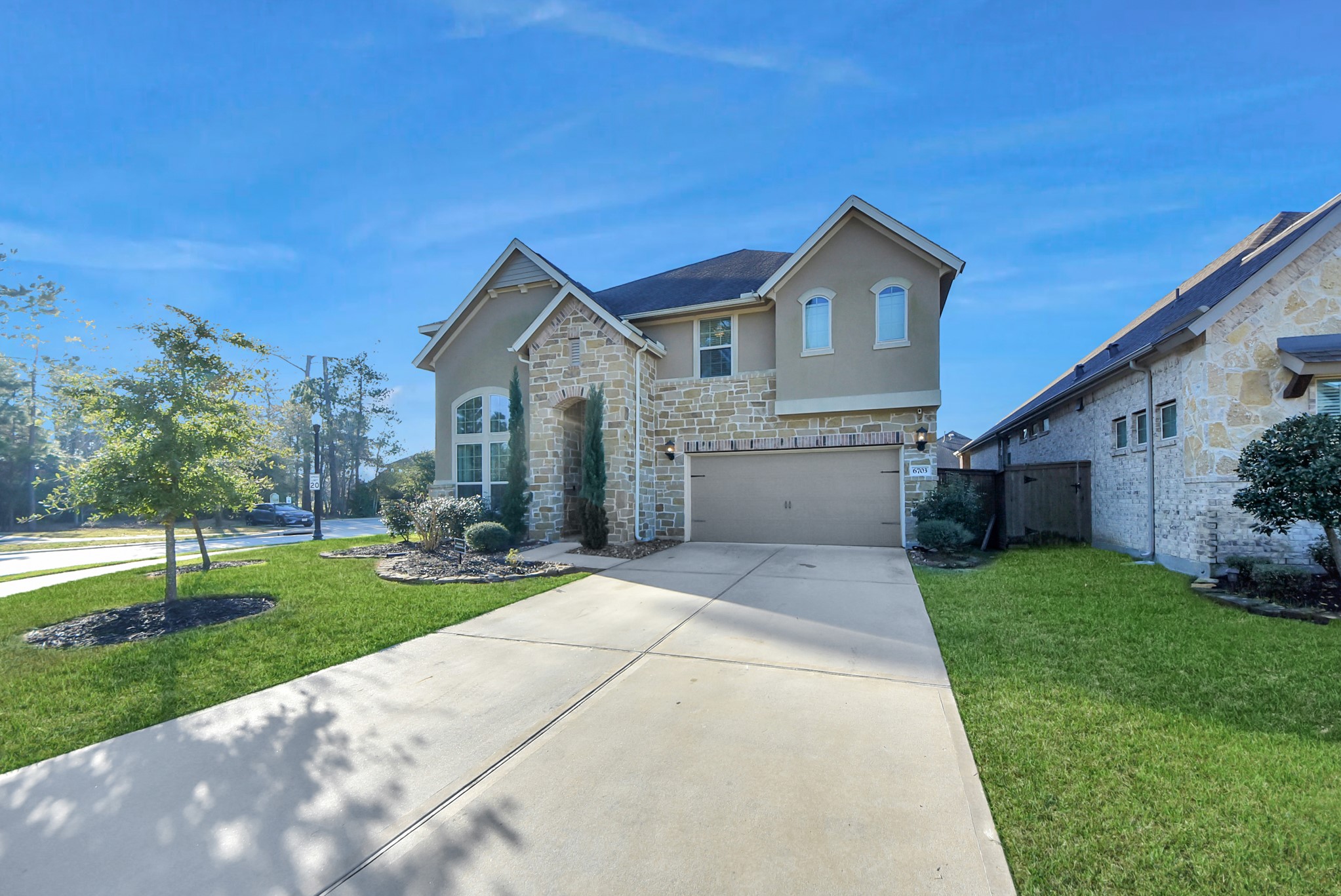 6703 Sandia Crest Street Spring, TX 77379 - Photo 3 of 45 a front view of a house with a yard and garage