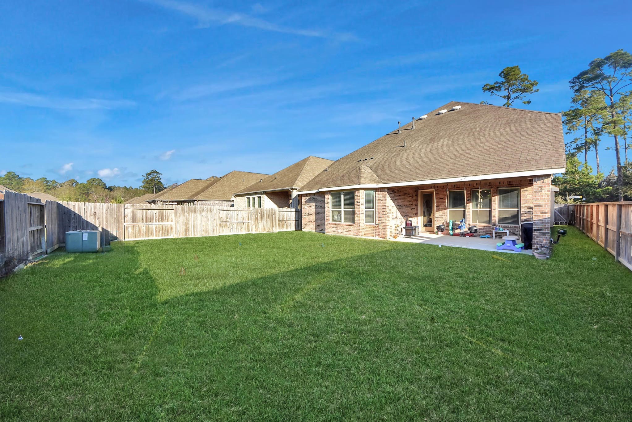 6703 Sandia Crest Street Spring, TX 77379 - Photo 37 of 45 a view of a house with a backyard porch and wooden fence