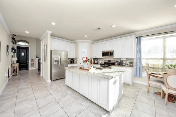 a kitchen with stainless steel appliances granite countertop a sink stove and refrigerator