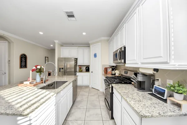 a large kitchen with stainless steel appliances granite countertop a lot of counter space and a sink