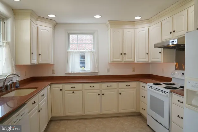 a kitchen with granite countertop white cabinets and stainless steel appliances