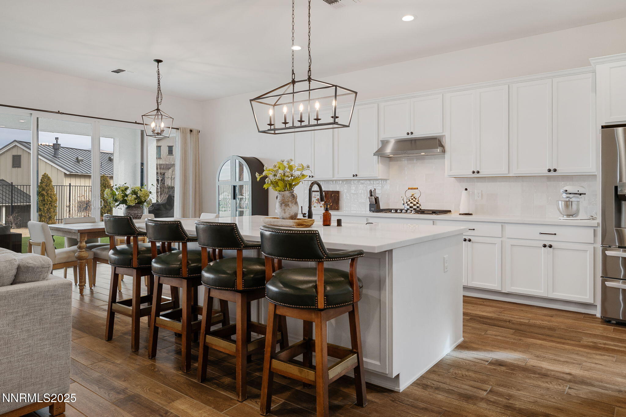 3011 Silverberry Lane Reno, NV 89521 - Photo 4 of 25 a open kitchen with stainless steel appliances granite countertop a dining table chairs stove and white cabinets
