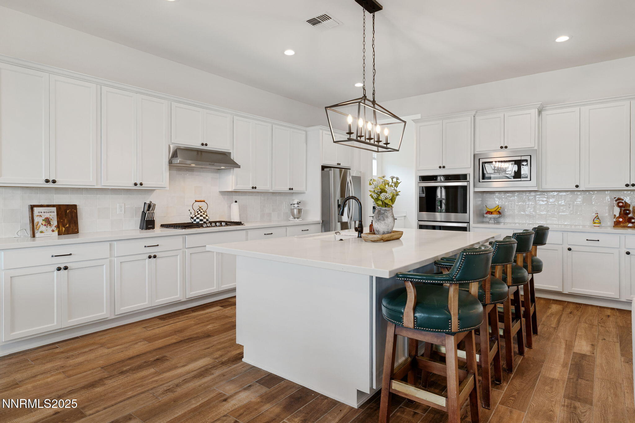 3011 Silverberry Lane Reno, NV 89521 - Photo 5 of 25 a kitchen with stainless steel appliances kitchen island granite countertop a wooden floor and white cabinets